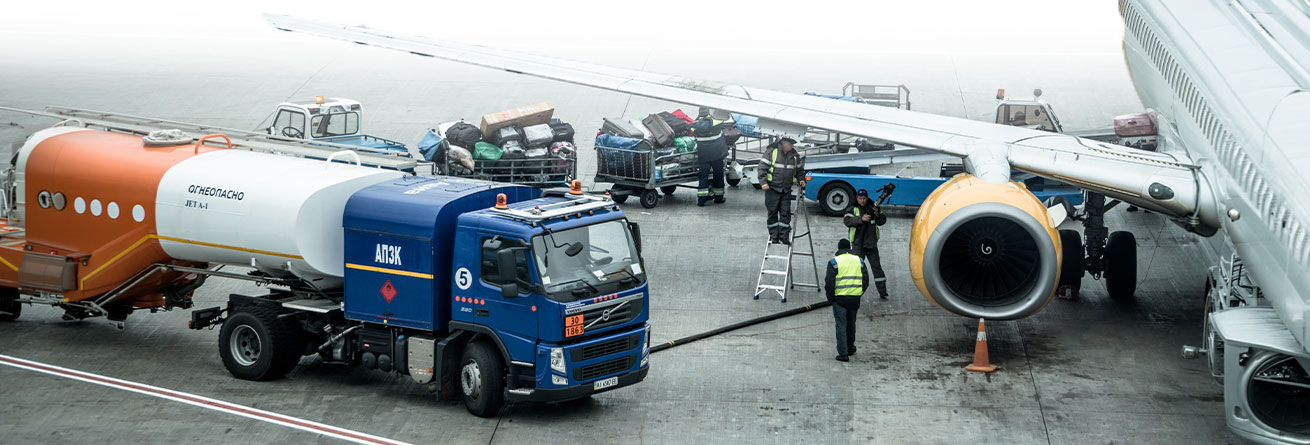 Ein Tankfahrzeug versorgt ein Flugzeug mit Treibstoff, w&auml;hrend das Bodenpersonal die Betankung koordiniert und weitere Abfertigungsprozesse vorbereitet.
