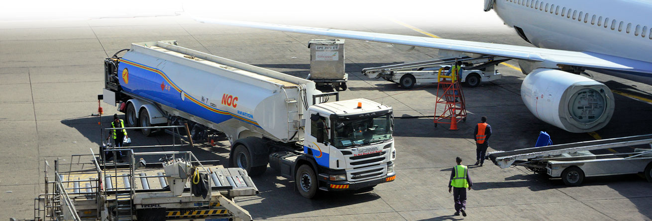 Ein Tankfahrzeug versorgt ein Flugzeug auf dem Vorfeld mit Treibstoff und unterst&uuml;tzt gemeinsam mit dem Bodenpersonal einen reibungslosen und sicheren Flugbetrieb.