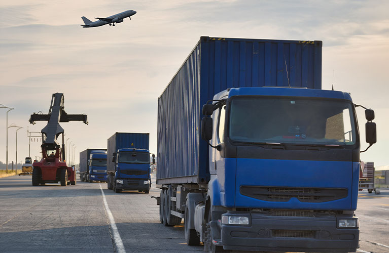 Transportfahrzeuge bewegen Container und Fracht auf dem Flughafengel&auml;nde und sorgen f&uuml;r einen sicheren sowie effizienten Ablauf der Bodenlogistik.