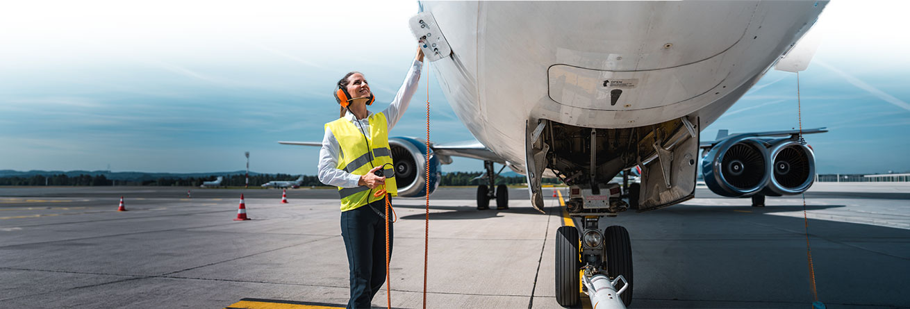 Eine Flugger&auml;tmechanikerin &uuml;berpr&uuml;ft ein Flugzeug vor dem Einsatz, kontrolliert technische Systeme und stellt die sichere Betriebsbereitschaft der Maschine sicher.